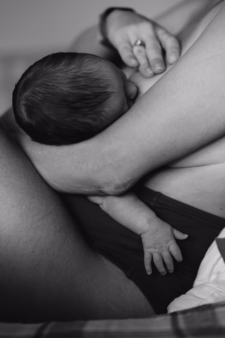 Newborn feeding, held close in a quiet moment